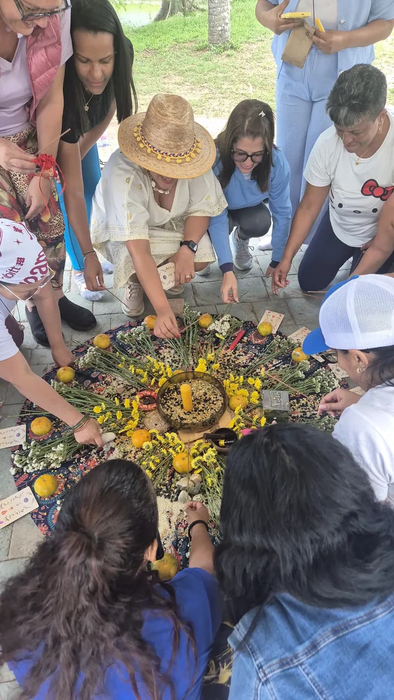 Participantes alrededor de un mandala de flores